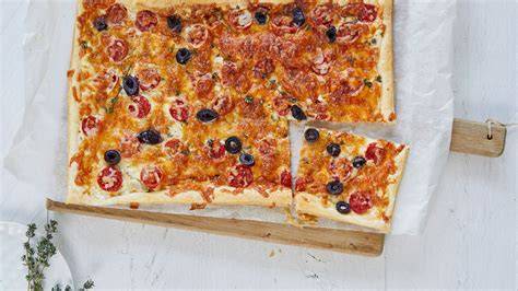 Frisch gebackene Blätterteigpizza mit Honig und Kirschtomaten serviert