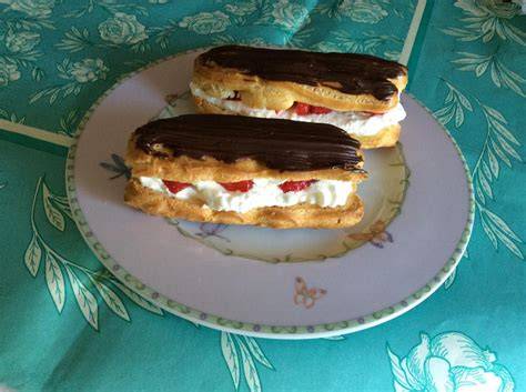 Frisch gebackene Eclairs gefüllt und mit Meringue abflämmt