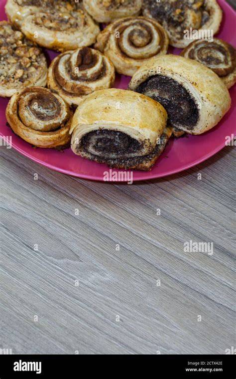 Frisch gebackene Mohn-Kringel auf einem Teller, gefüllt mit Aprikosen-Marmelade