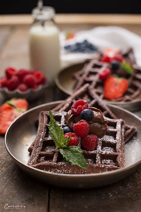 Frisch gebackene Schokowaffeln mit Puderzucker und Beeren