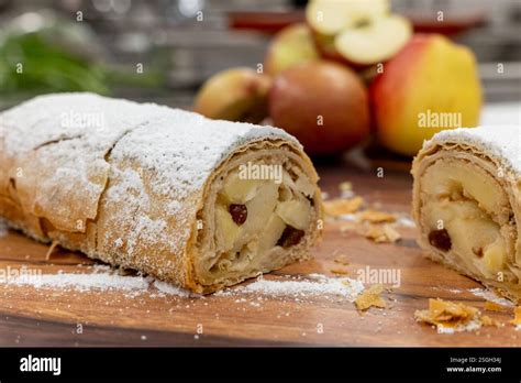 Frisch gebackener Apfel-Krokant-Kuchen auf einem Holzbrett mit Äpfeln und Nüssen