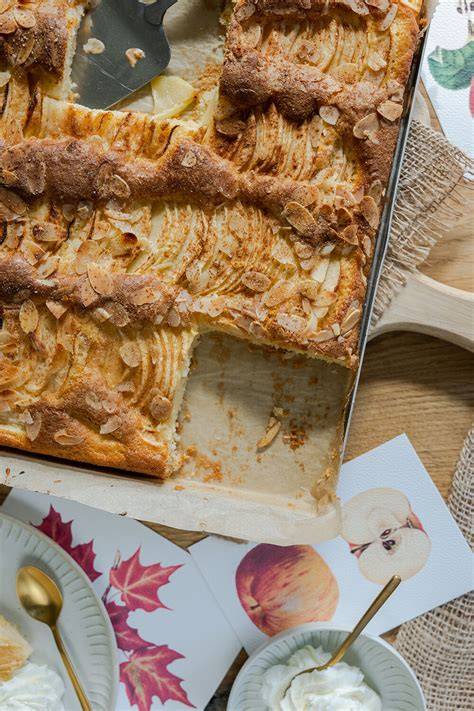 Frisch gebackener Apfelkuchen mit gerösteten Mandeln auf einer herbstlichen Tafel