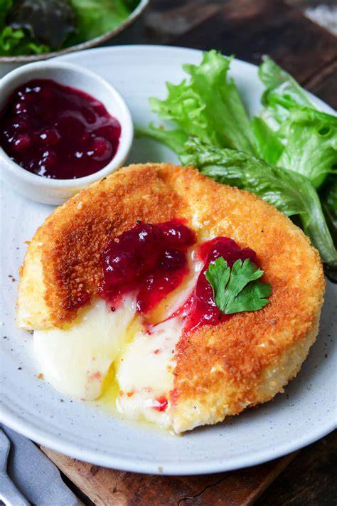 Frisch gebackener Camembert mit Honig und Kräutern, garniert mit Zitronenabrieb