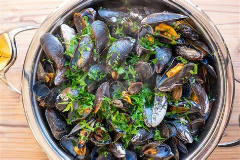 Frisch gekochte Miesmuscheln in einem großen Topf mit Gemüse