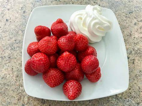 Frisch geschlagene Sahne mit Erdbeeren und Vanilledeko
