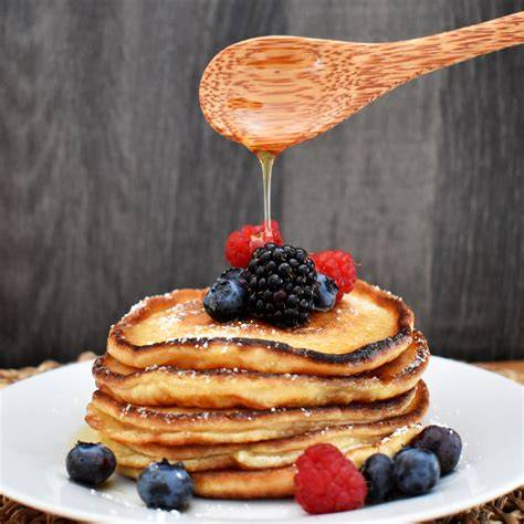 Frisch zubereitete Pancakes mit Beeren und Ahornsirup