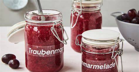 Frisch zubereitete Traubenmarmelade auf Brot, daneben Trauben und Thermomix-Gerät