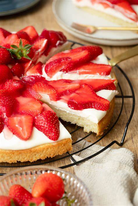 Frische, halbierte Erdbeeren auf Paradiescreme verteilt