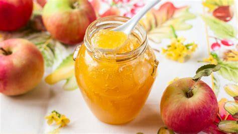 Frische Äpfel und Apfelmarmelade in Einmachgläsern
