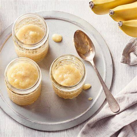 Frische Bananen und Bananenmarmelade in Gläsern