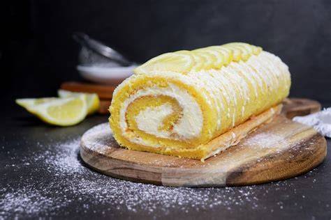 Frische Biskuitrolle mit Zitronencreme auf Tortenplatte