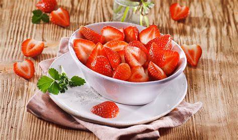 Frische Erdbeeren halbiert zum Belegen des Kuchenbodens