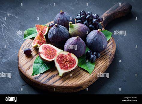Frische Feigen und rote Johannisbeeren auf einem Holzbrett