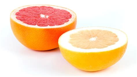 Frische Grapefruit-Scheiben mit rosafarbenem Fruchtfleisch und Saft