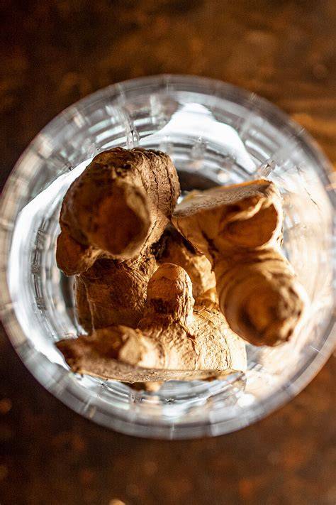 Frische Ingwerwurzeln und verschiedene Marmeladensorten im Glas