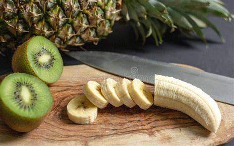 Frische Kiwis und Bananen auf Schneidebrett