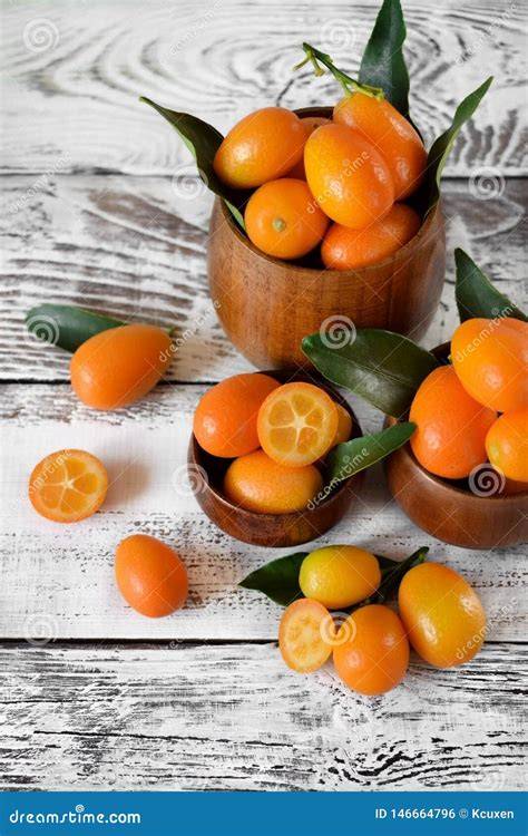 Frische Kumquats und Orangen auf Holzbrett