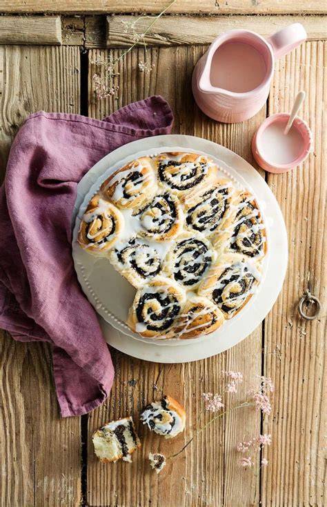 Frische Mohnschnecken mit Zuckerguss auf Blech, dekoriert mit Streuseln