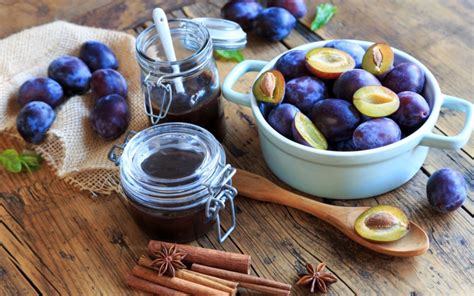 Frische Pflaumen, Gewürze und Stevia als Zutaten arrangiert