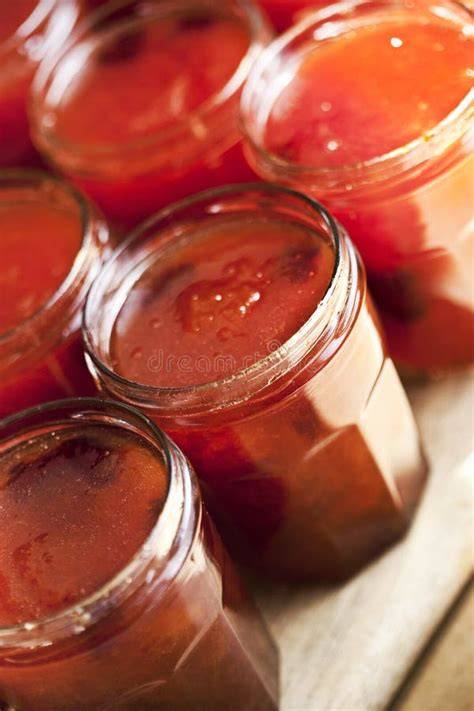 Frische Physalisfrüchte und Marmeladengläser auf einem Holztisch