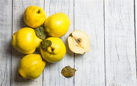Frische Quitten und Dessertzutaten auf rustikalem Untergrund