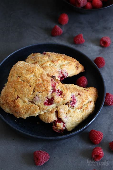 Frische Scones mit Himbeeren und weißer Schokolade auf einem Teller