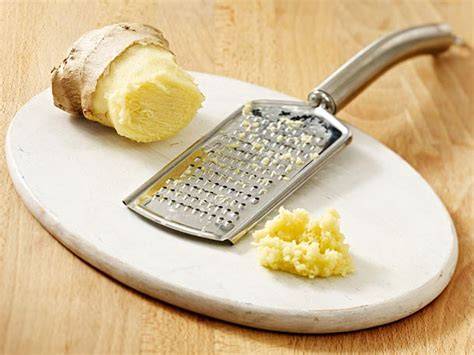 Frische Thymianblättchen und geriebener Ingwer auf einem Brett