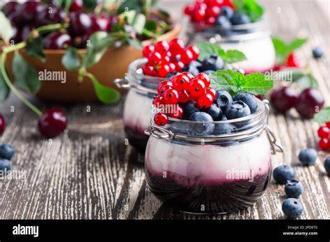 Frische rote Johannisbeeren und Joghurt in Dessertgläsern serviert