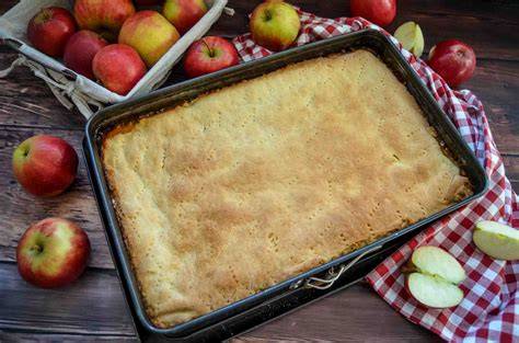 Frischer Apfelkuchen, bestäubt mit Puderzucker, angerichtet auf Blech