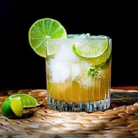 Frischer Caipirinha mit Limetten und braunem Zucker in einem Tumbler