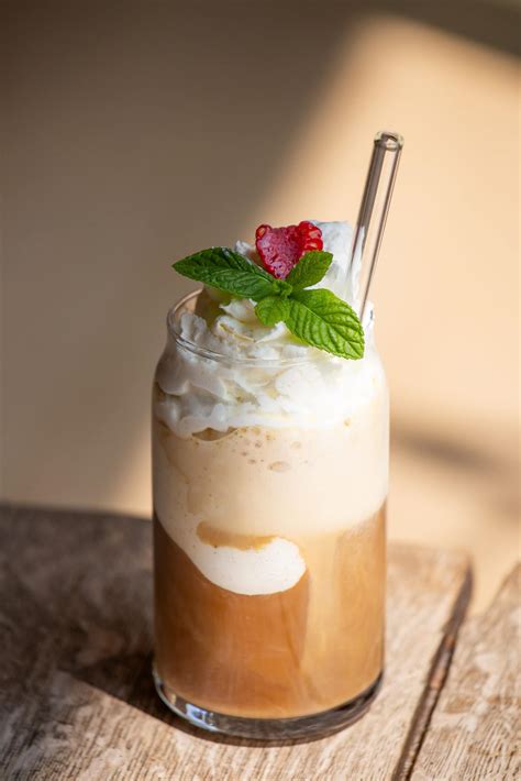 Frischer Eiskaffee in einem Glas, Zutaten im Hintergrund