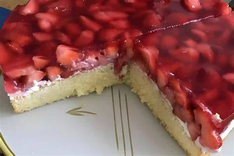 Frischer Erdbeerkuchen mit Schmand, Erdbeeren und glänzendem Guss auf einer Tortenplatte