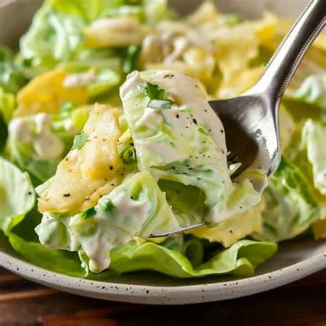 Frischer Kopfsalat mit cremigem Milch-Zucker-Dressing, angerichtet mit Schnittlauch