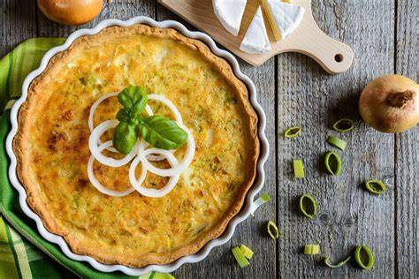 Frischer Lauch und Zwiebeln als Hauptzutaten für Zwiebelkuchen