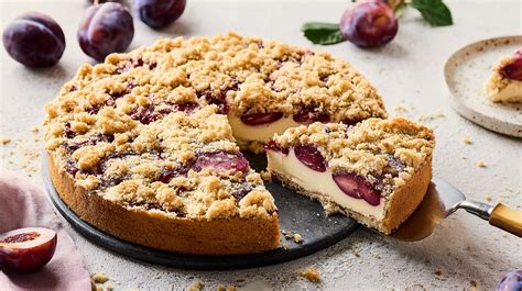 Frischer Pflaumenkuchen mit Pudding und Streuseln auf einer Kaffeetafel