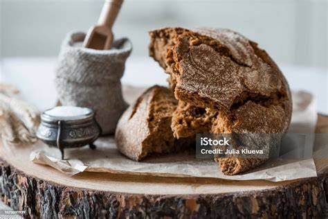Frisches Sauerteigbrot und Honig auf einem Holztisch