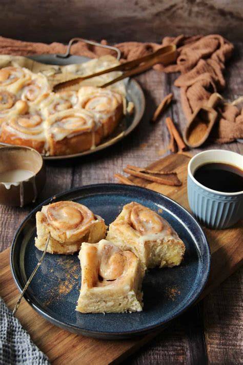 Frischkäse-Frosting auf Zimtschnecke, Gabel sticht hinein