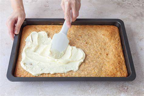 Frischkäse-Frosting wird glatt auf dem Kuchen verteilt