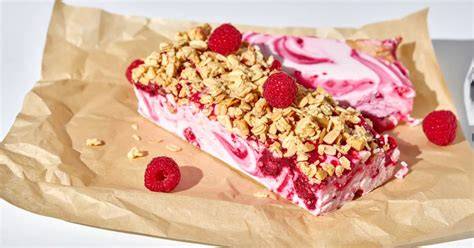 Frozen Joghurt Bite-Schnitten mit Himbeer-Swirl und Mandel Crunch dekoriert