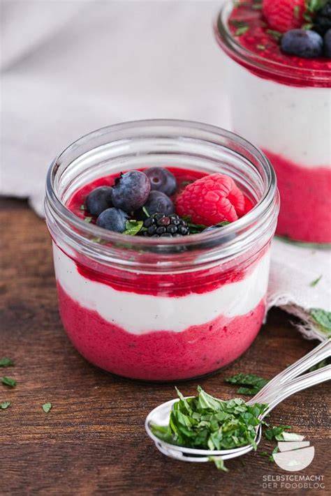 Frozen Yogurt im Glas, angerichtet mit frischen Beeren und Minze