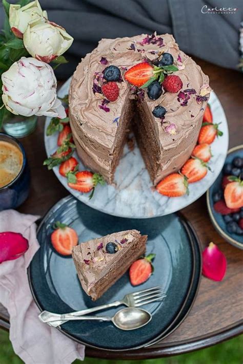 Ganache-Torte mit Beeren, Schokoladendeko und essbaren Blüten