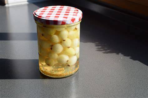 Ganze fermentierte Silberzwiebeln im Glas