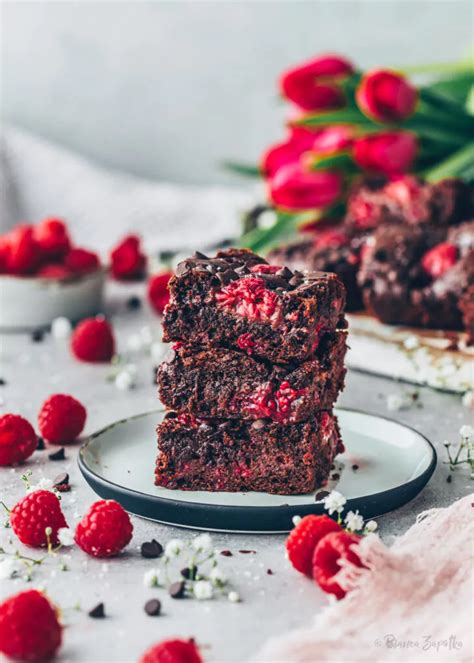 Garnierte Brownie Käsekuchenstücke mit Himbeeren und Nüssen