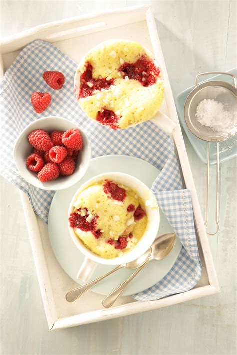 Garnierte Tassenkuchen mit Ganache und Himbeeren