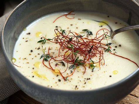 Garnierte Topinambursuppe mit weißer Schokolade, Chilifäden und Passionsfrucht