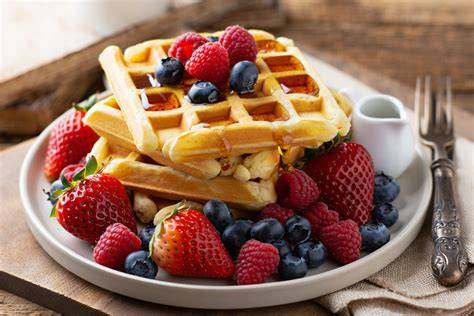 Garnierte Waffeln mit Ahornsirup und frischen Beeren