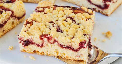 Gebackener Marmeladen-Streuselkuchen angeschnitten mit Vanilleeis