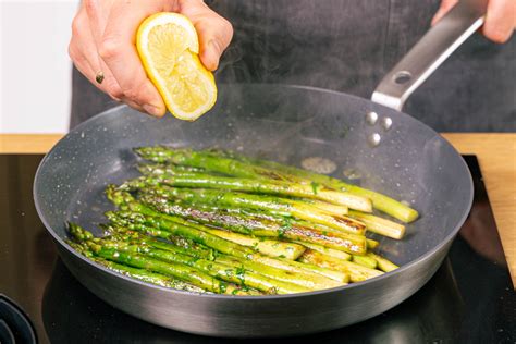 Gebratener grüner Spargel mit Honig und Chili in der Pfanne