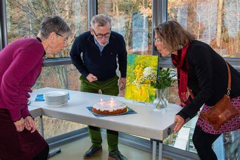Geburtstagsfeier: Gäste pusten die Kerzen auf einer 60er-Torte aus