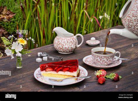 Gedeckter Tisch mit Stück Erdbeer-Marzipan-Kuchen und Kaffee